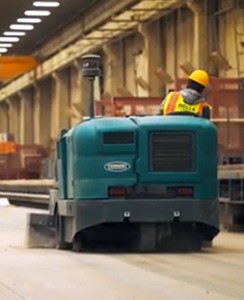 Tennant Company floor sweeper with HEPA filter cleaning silaca dust on manufacturing floor